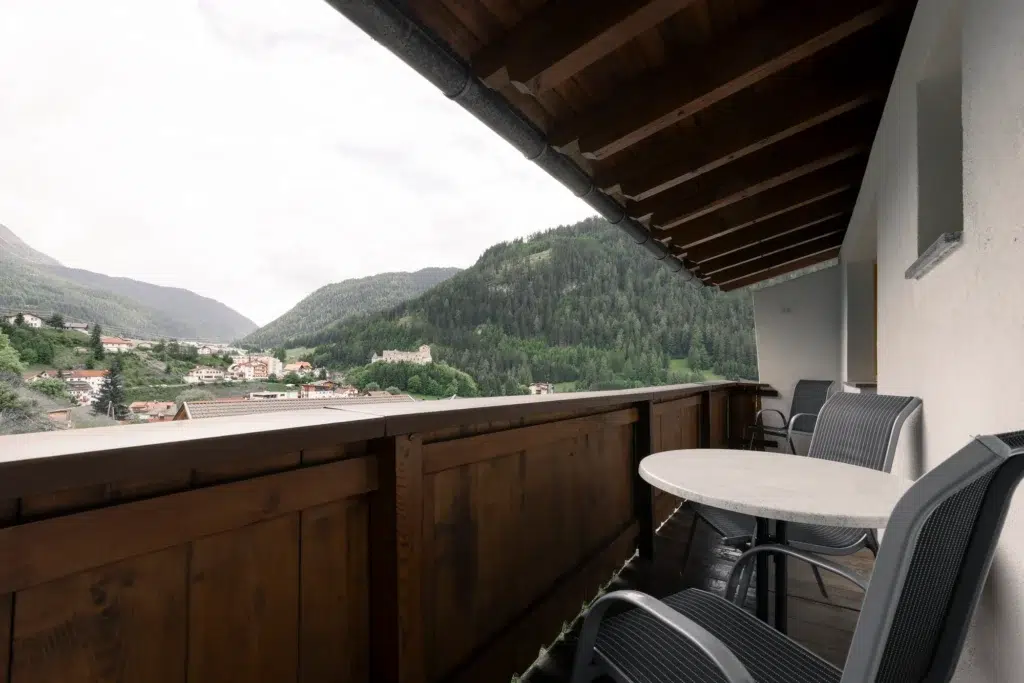 Gemütlicher Balkon mit zwei Stühlen und einem kleinen Tisch und einem atemberaubenden Blick auf die Berge und das Tal von Nauders.